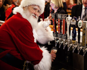 Santa pouring Adams Street beer